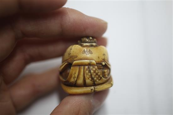 A Japanese ivory netsuke carved with nine Noh masks and another of a seated man asleep, both signed (2)